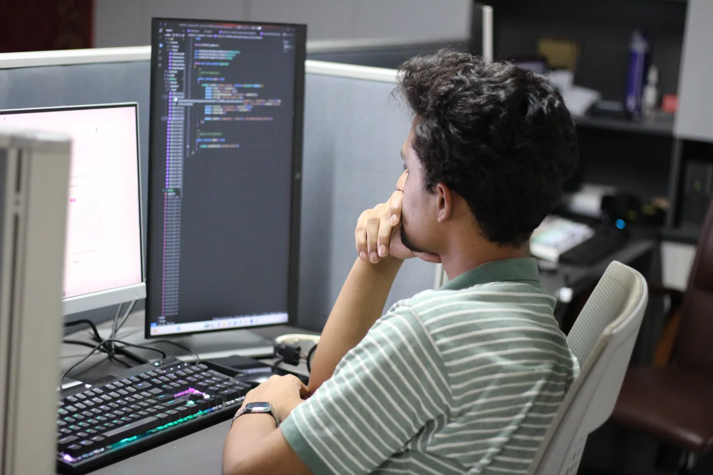 Walid Forhad writing code at a dual monitor desk