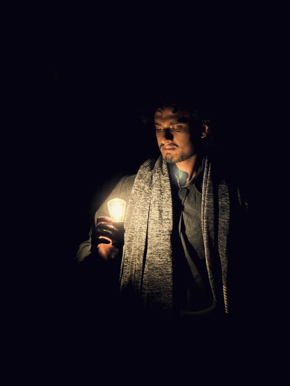 Walid Forhad holding a lit bulb in the dark