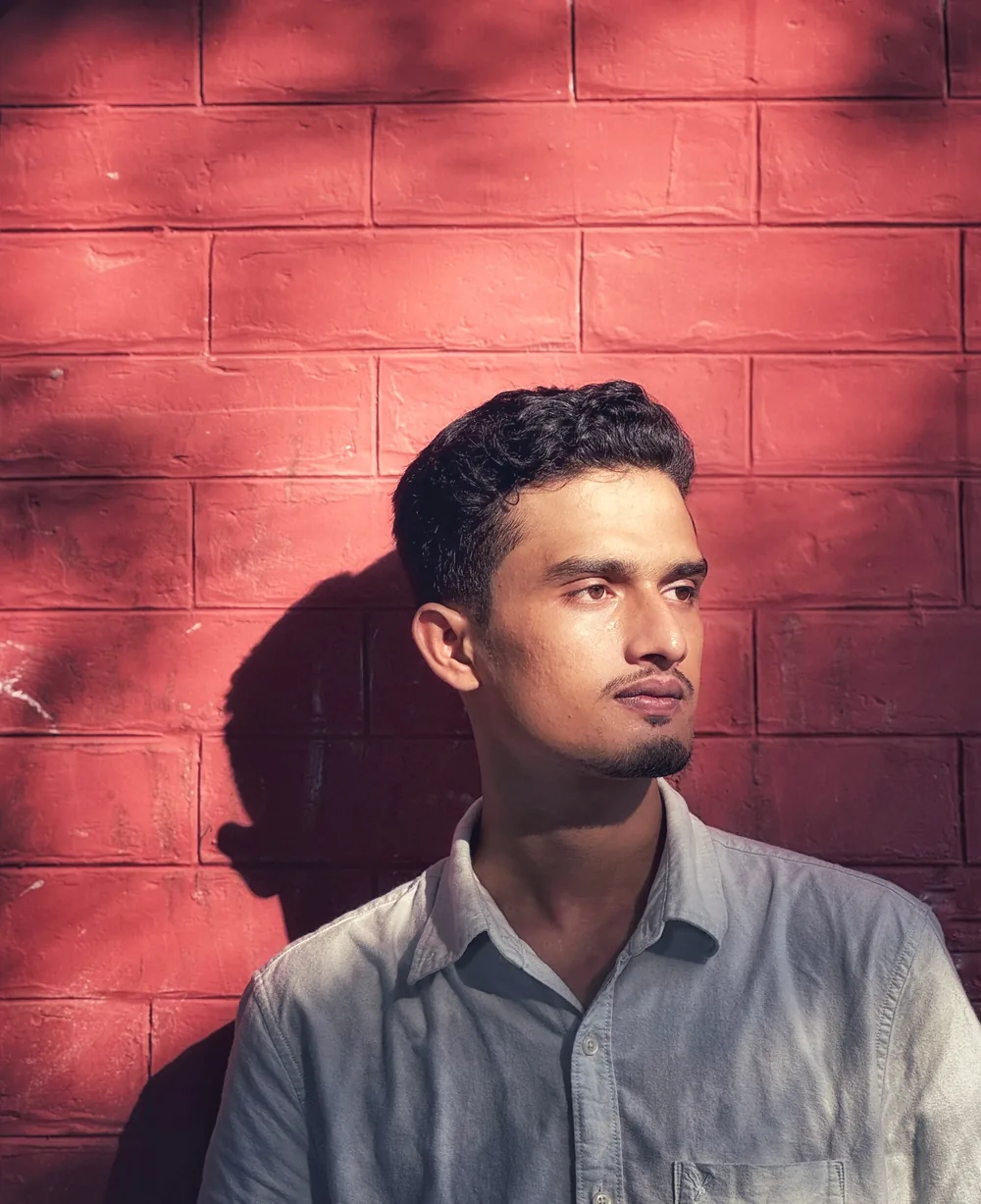 Walid Forhad portrait against a red brick wall